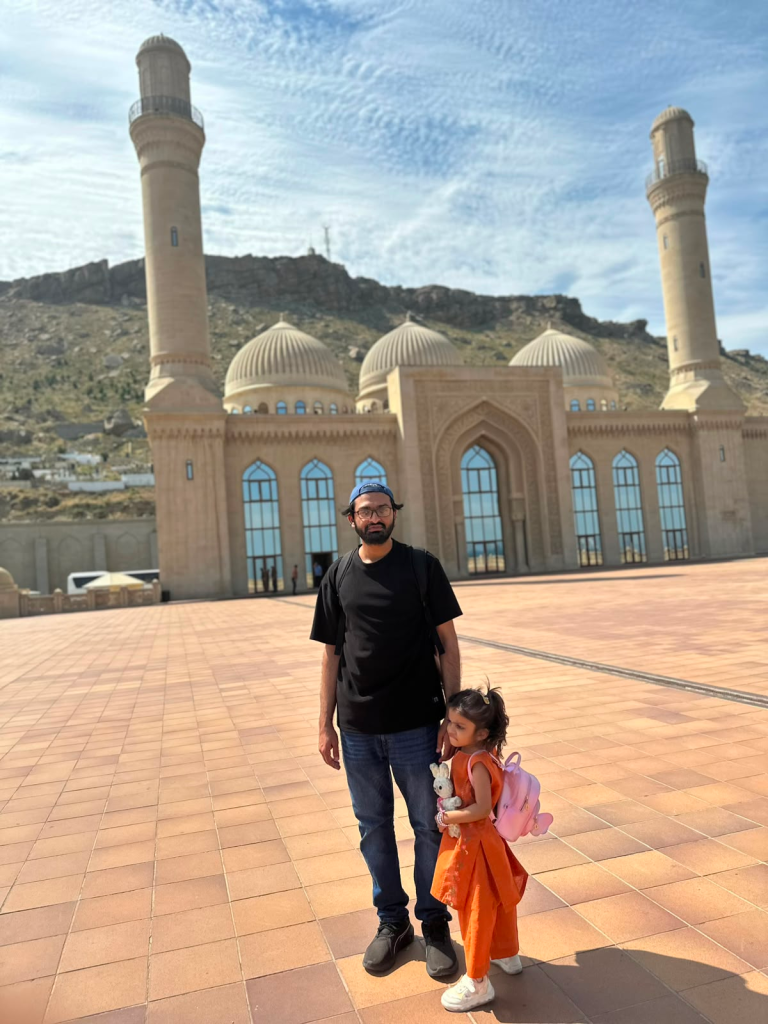 Faisal and his daughter Fatima standing outside Bibi-Heybat Mosque in Baku, Azerbaijan