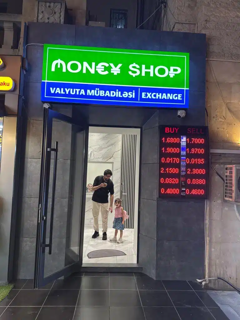 Faisal and his daughter at a currency exchange office in 28 May Baku