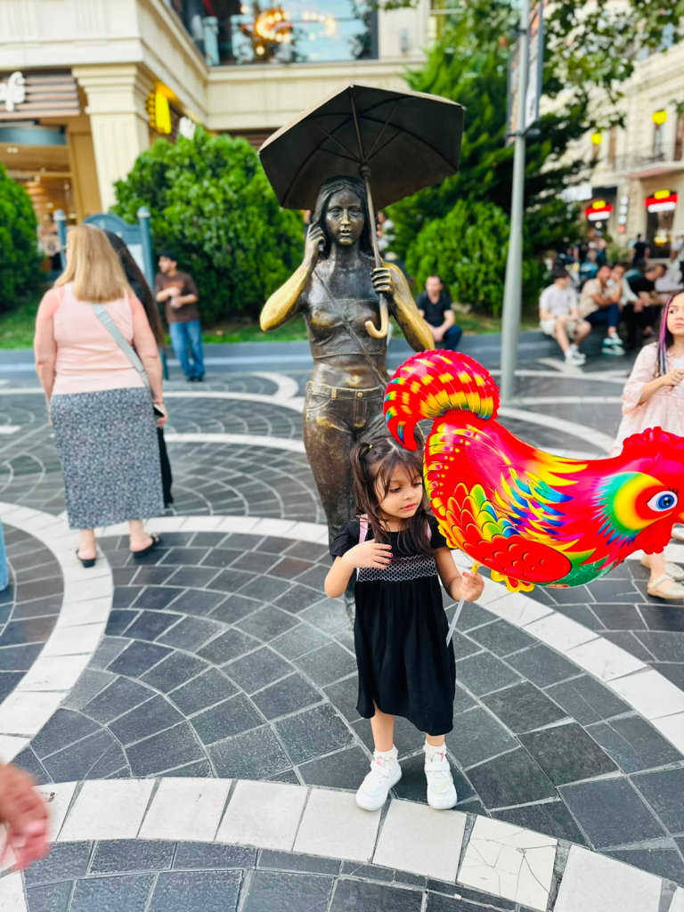 Fatima enjoying a colorful balloon on Nizami Street in Baku